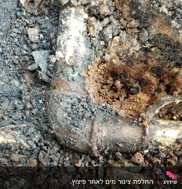 צינור מתכת ישן באדמה עם חלודה ונזק